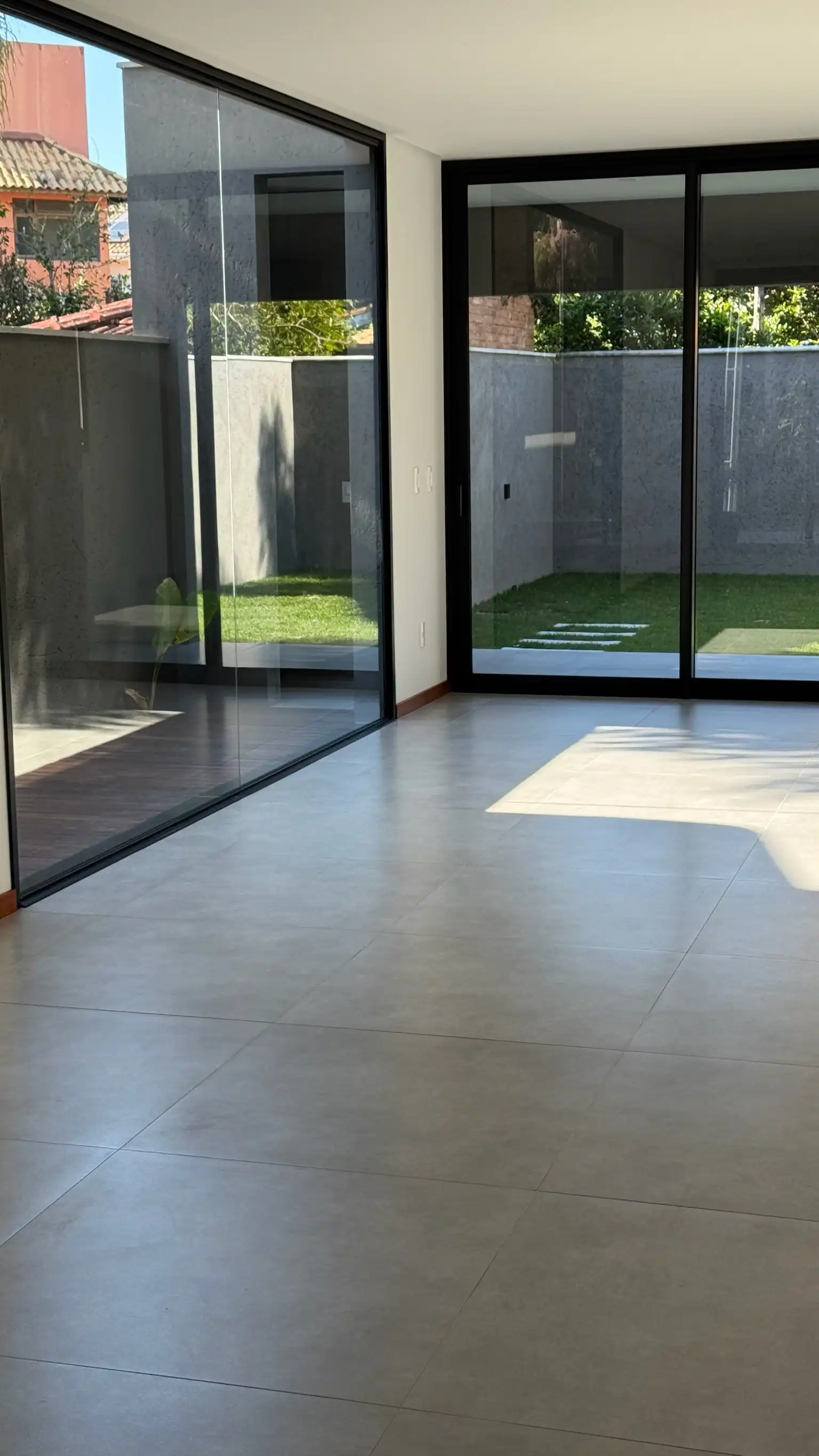 Großzügiges Wohnzimmer des Architektenhauses mit Glasschiebetüren zum Innenhof - Florianópolis